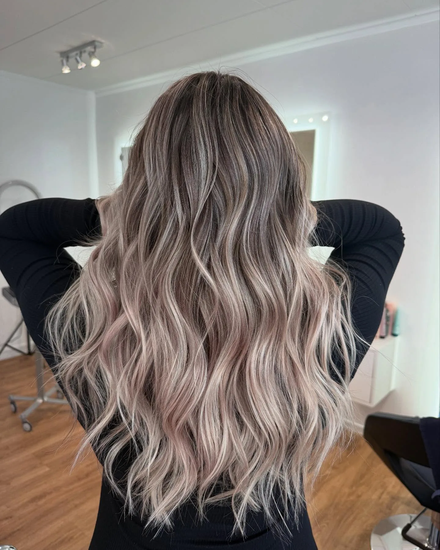 Balayage cendré rose sur cheveux longs ondulés