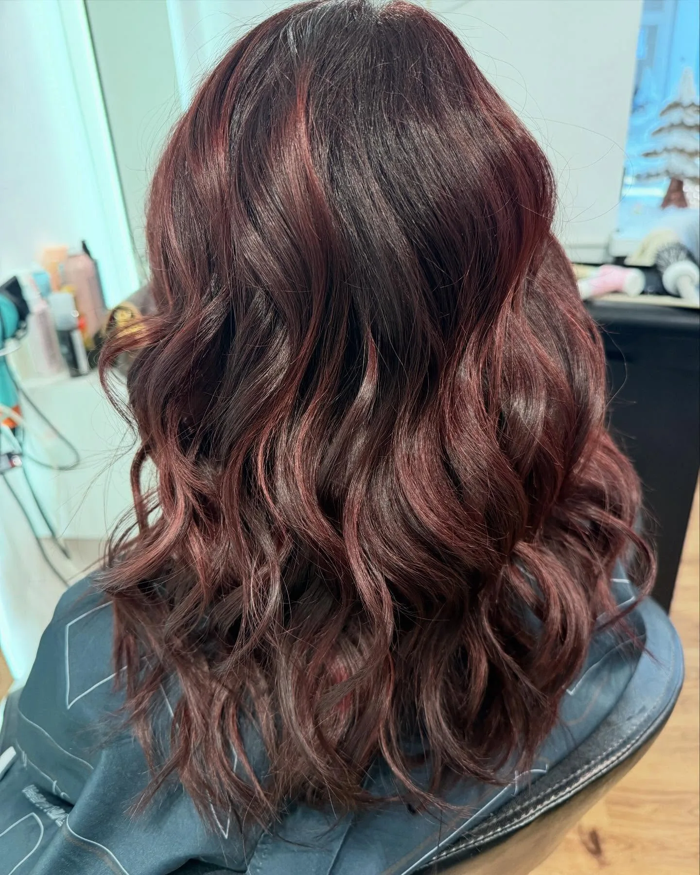 Coloration rouge auburn brillante sur cheveux ondulés